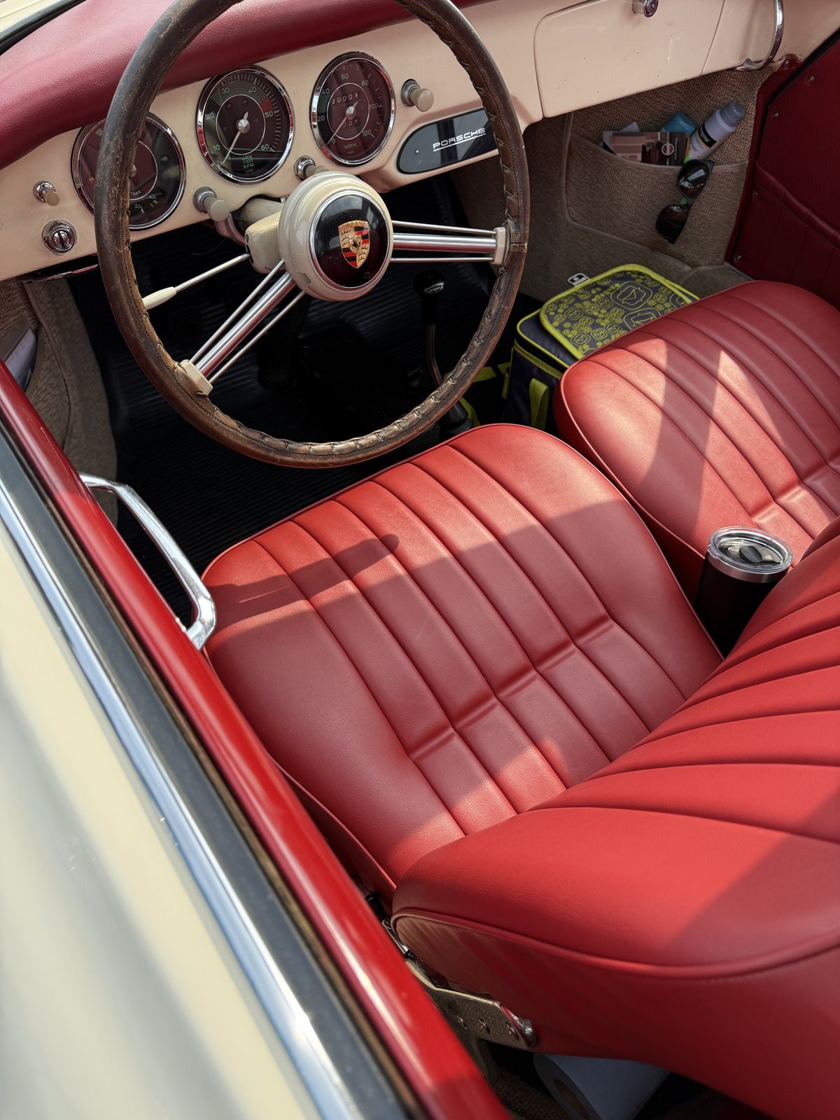 Porsche 356 interior with red leather seats and a wood rim steering wheel